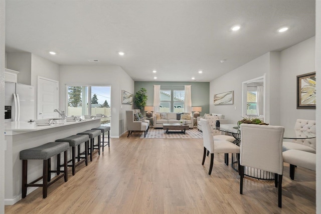 dining area with a textured ceiling, light wood-type flooring, and plenty of natural light