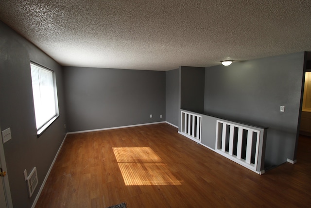 spare room with a textured ceiling and wood-type flooring