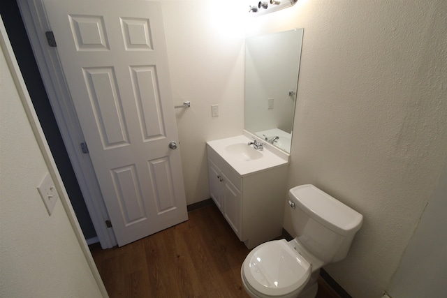 bathroom with vanity, hardwood / wood-style floors, and toilet