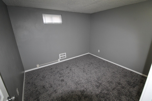 unfurnished room with carpet and a textured ceiling