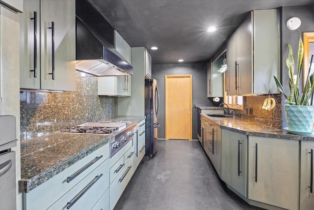 kitchen with appliances with stainless steel finishes, wall chimney exhaust hood, sink, and decorative backsplash