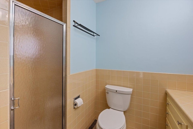 bathroom featuring tile walls, vanity, toilet, and walk in shower