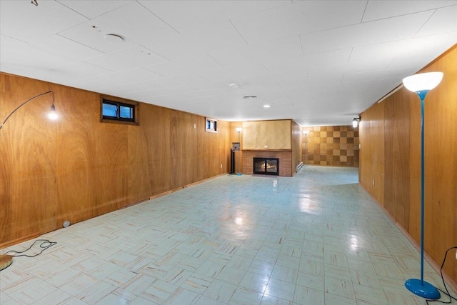 basement featuring wooden walls and a fireplace