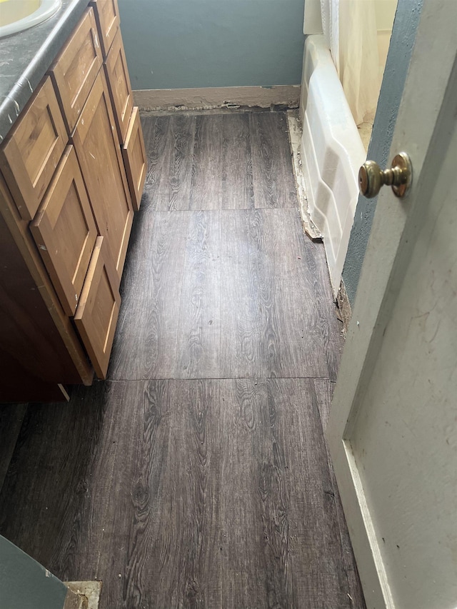 full bath with a tub, wood finished floors, and vanity