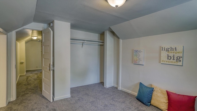 carpeted bedroom with vaulted ceiling and a closet