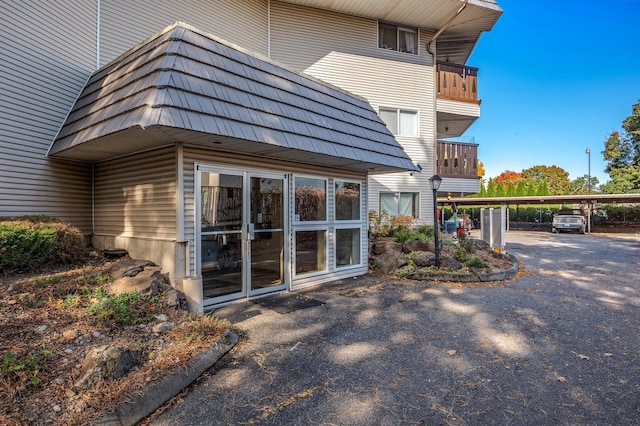 view of home's exterior with a balcony and a carport