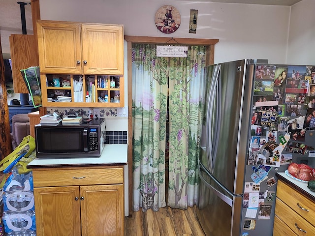 kitchen with hardwood / wood-style floors and stainless steel fridge