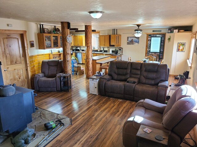 living room featuring a textured ceiling, dark wood-type flooring, and ceiling fan