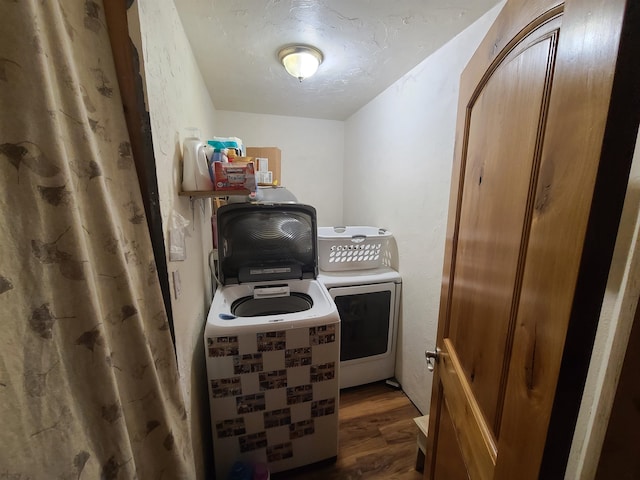 clothes washing area featuring independent washer and dryer, a textured ceiling, and dark hardwood / wood-style flooring