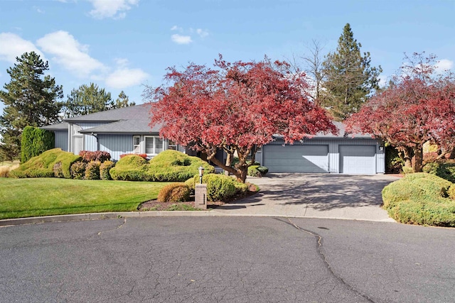 view of front of property featuring a garage and a front lawn