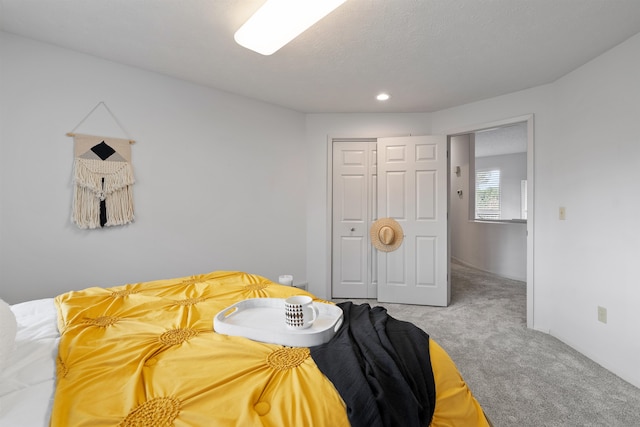 bedroom featuring a textured ceiling, carpet flooring, and a closet