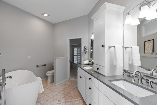 bathroom featuring vanity, a bath, toilet, and tile patterned floors