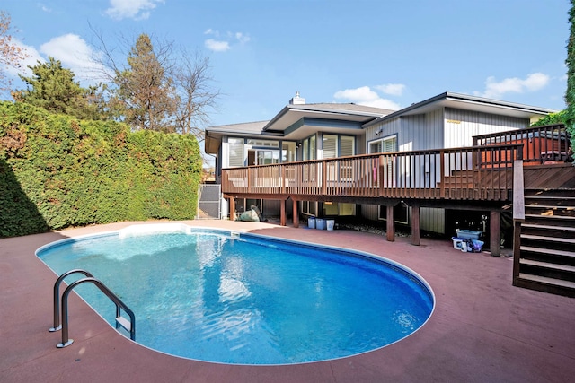 view of swimming pool featuring a wooden deck and a patio