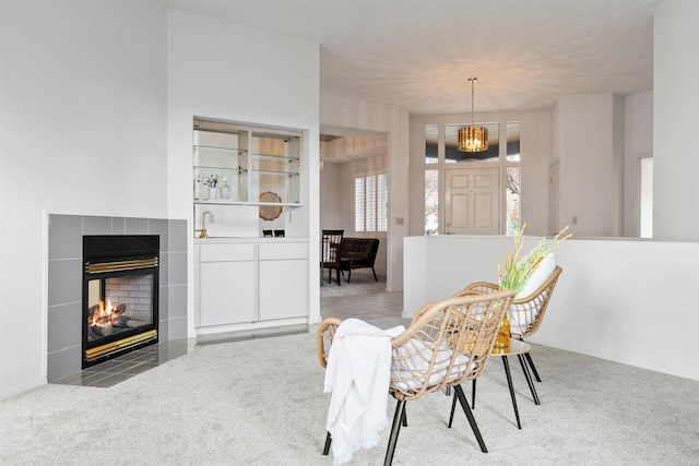 carpeted dining area with a tile fireplace