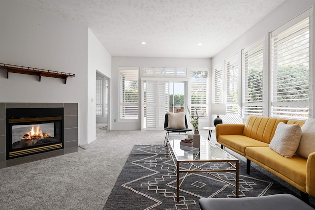 carpeted living room with a textured ceiling and a fireplace