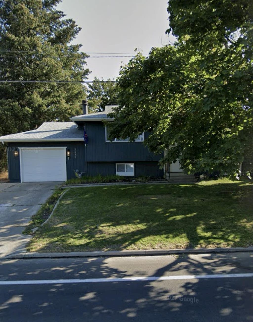 7612 N Standard St, Spokane, WA 99208 - split level home with an attached garage, driveway, and a front lawn