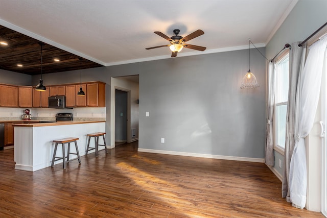 kitchen featuring black appliances, ceiling fan, decorative light fixtures, a breakfast bar area, and dark hardwood / wood-style floors