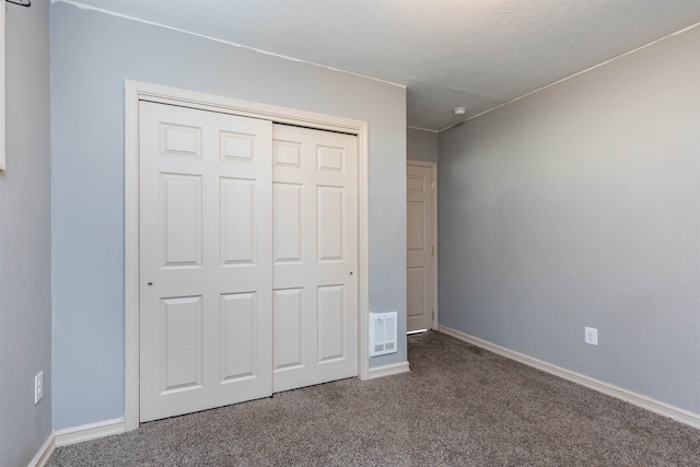 unfurnished bedroom with a closet, carpet flooring, and a textured ceiling