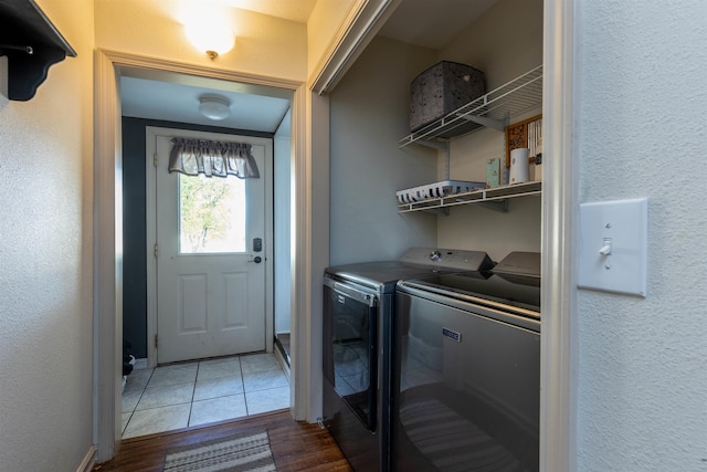 clothes washing area with wood-type flooring and separate washer and dryer