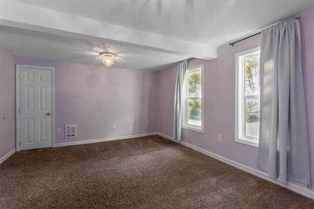 carpeted empty room with beamed ceiling