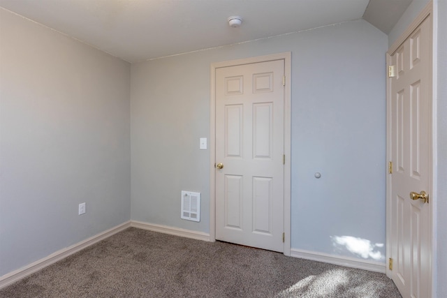 unfurnished room with carpet and vaulted ceiling