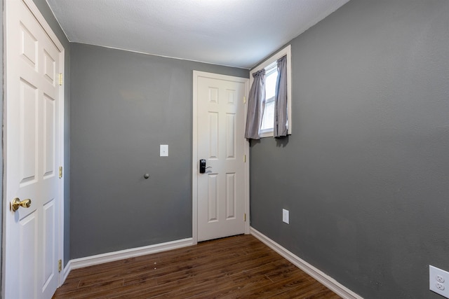 entryway with dark wood-type flooring and a textured ceiling