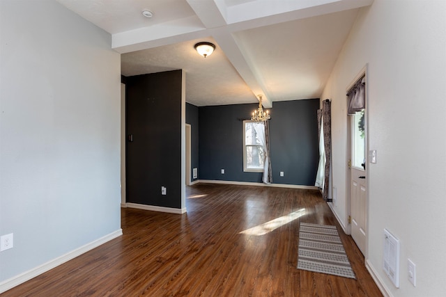 empty room featuring coffered ceiling, beam ceiling, a notable chandelier, and dark hardwood / wood-style floors