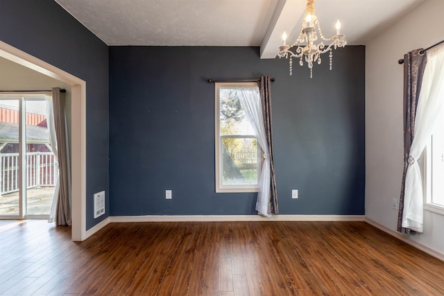 unfurnished room with beam ceiling, wood-type flooring, and an inviting chandelier