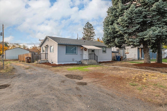 view of front of house with roof with shingles and fence