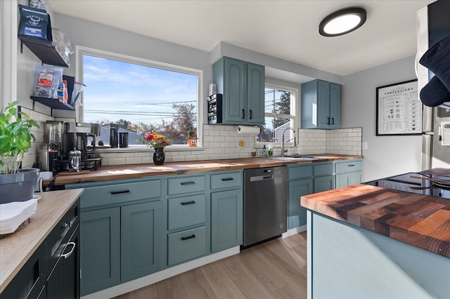 kitchen with a wealth of natural light, dishwasher, light hardwood / wood-style flooring, and wood counters