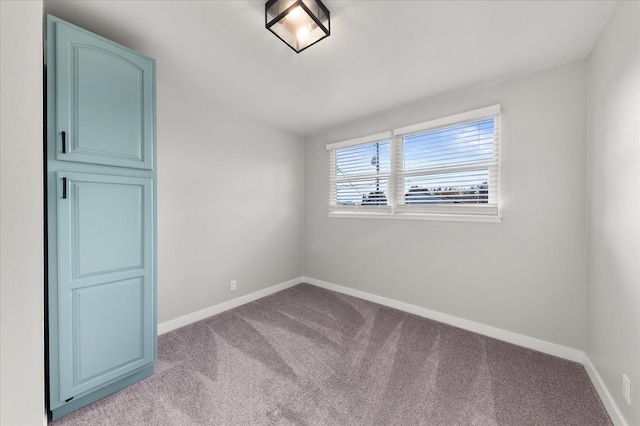 empty room with light colored carpet and baseboards