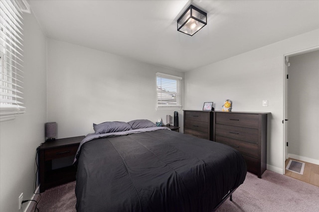 carpeted bedroom featuring baseboards and visible vents