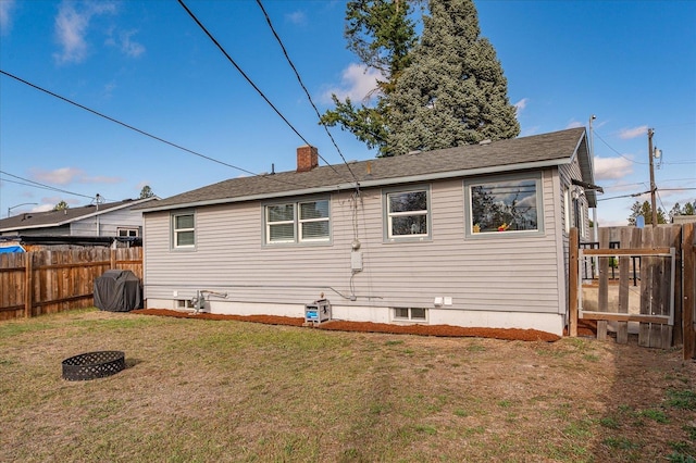 back of property with a lawn, a chimney, and fence private yard