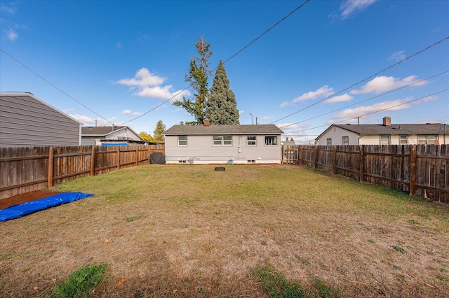 back of property featuring a fenced backyard and a yard