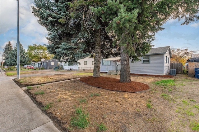 view of front of home with cooling unit and fence