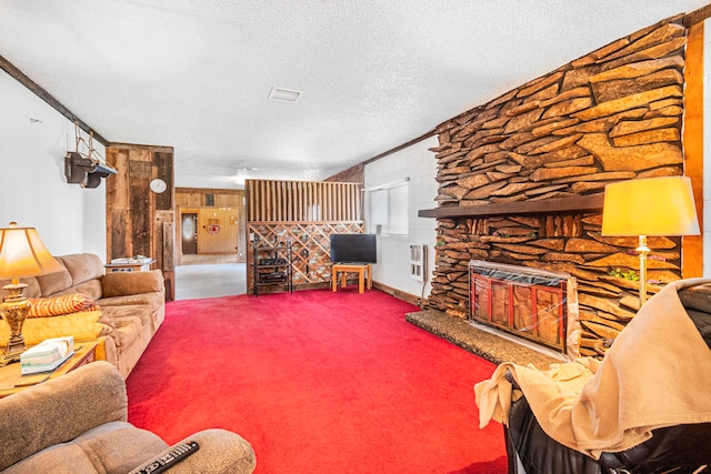 carpeted living room featuring a textured ceiling, crown molding, and a fireplace