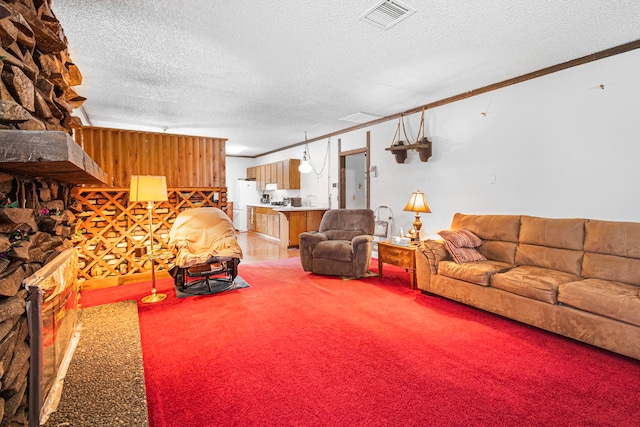 living room featuring carpet flooring, a textured ceiling, and ornamental molding