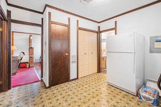 kitchen featuring white fridge, crown molding, and a textured ceiling