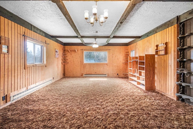 unfurnished room with wood walls, ceiling fan with notable chandelier, a textured ceiling, beamed ceiling, and baseboard heating