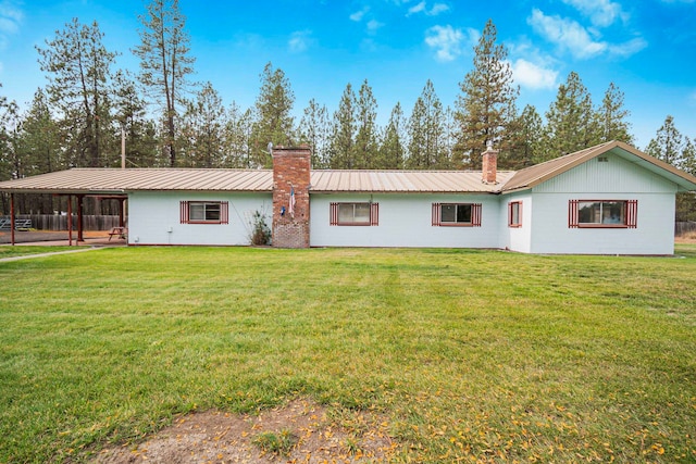 rear view of property featuring a yard and a carport