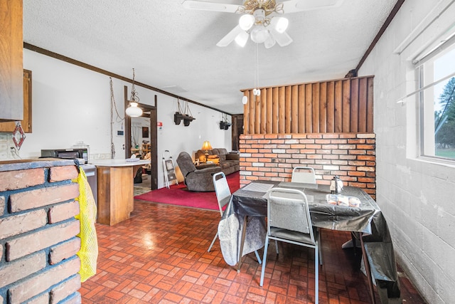 dining room with crown molding, a textured ceiling, and ceiling fan