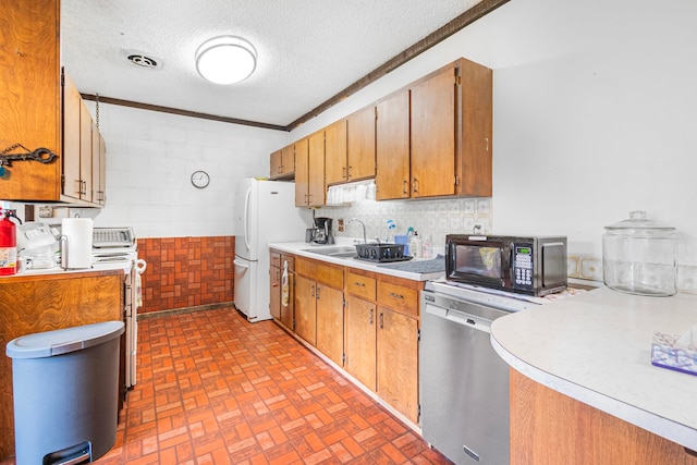 kitchen with ornamental molding, sink, stainless steel dishwasher, white fridge, and a textured ceiling