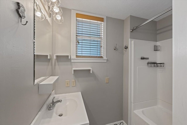 bathroom with  shower combination, vanity, and a textured ceiling