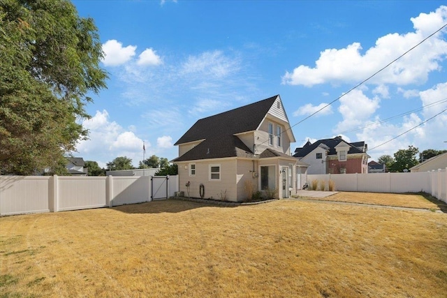 rear view of house featuring a lawn