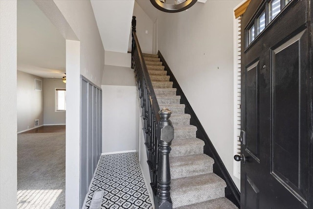 stairway featuring carpet floors and ceiling fan