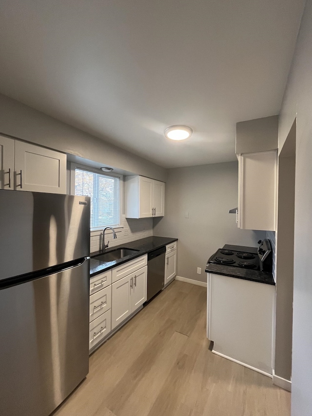 kitchen with white cabinetry, stainless steel appliances, sink, and light wood-type flooring