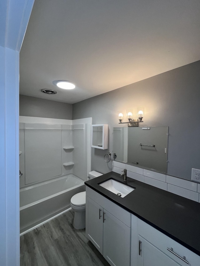 full bathroom featuring vanity, hardwood / wood-style floors, toilet, and shower / bathtub combination