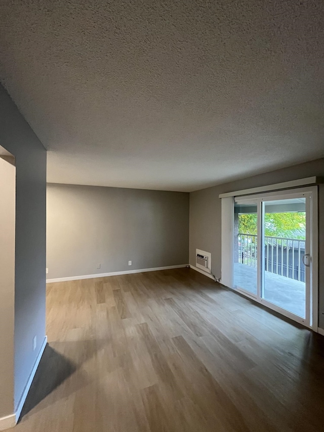 unfurnished room with a textured ceiling and light wood-type flooring