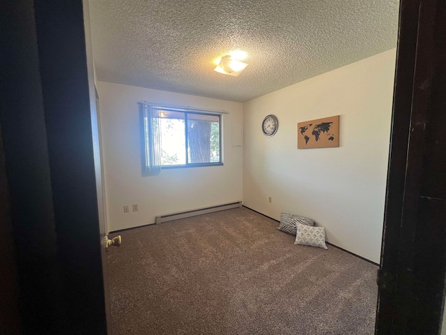 carpeted spare room featuring a baseboard heating unit and a textured ceiling