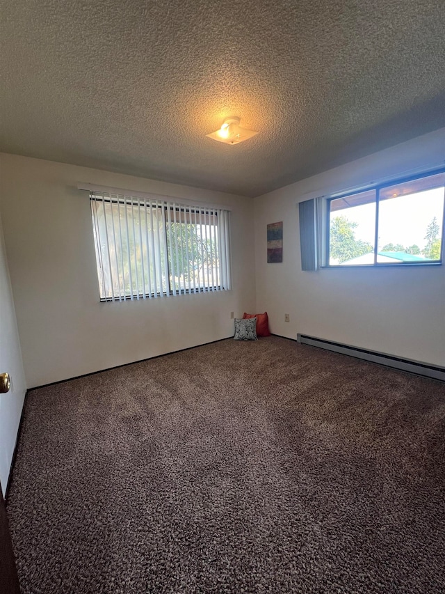 unfurnished room with a textured ceiling, carpet, and a baseboard heating unit